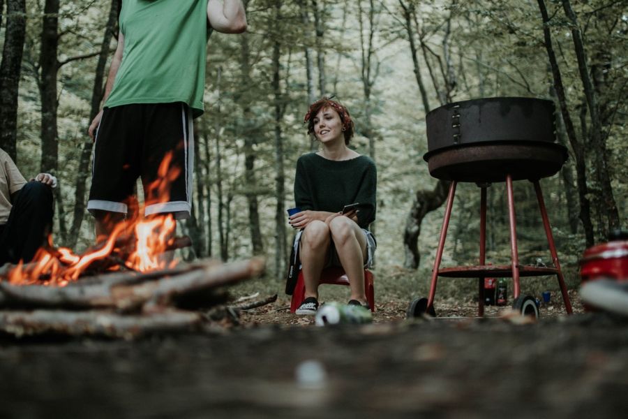 Dievča v lese sa chystá na grilovanie pri ohni