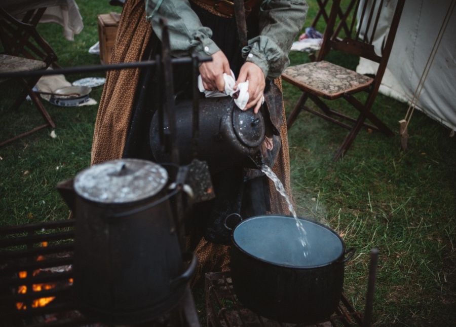 Žena varí vodu v prírode